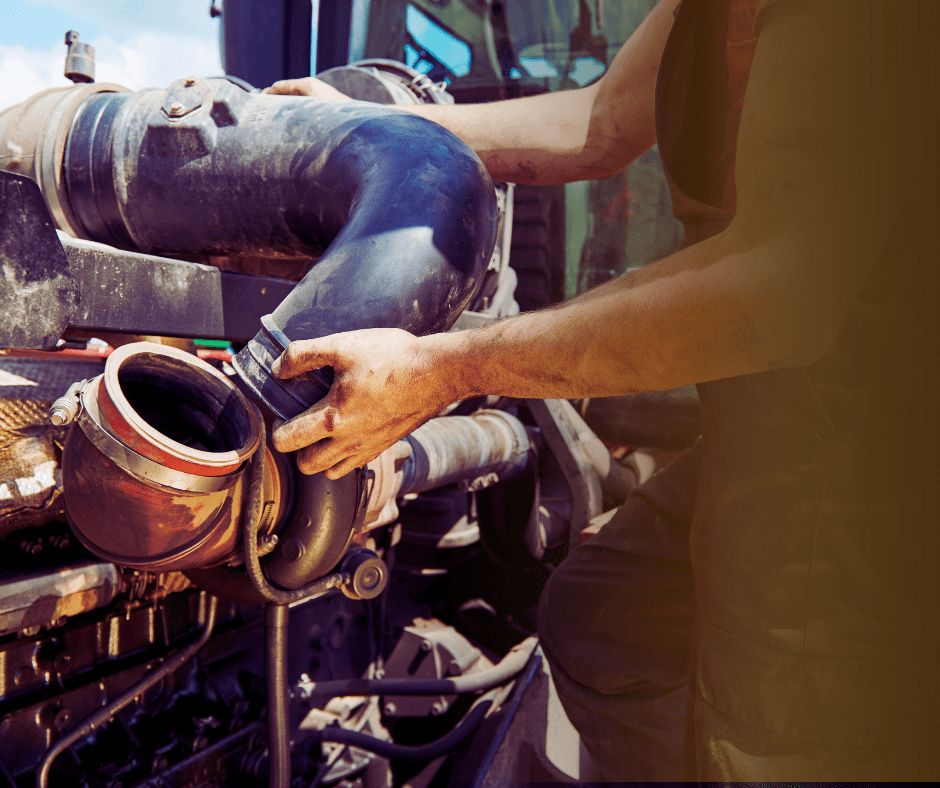 Mechanic repairing heavy machinery pipe connection.