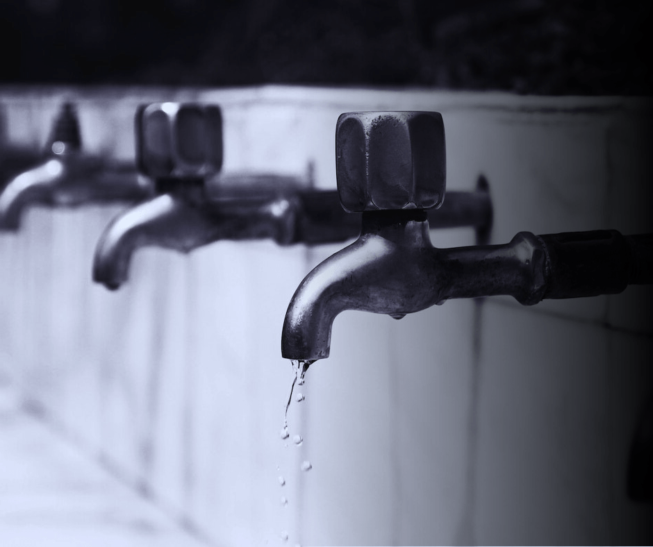 Water dripping from old taps, monochrome image.