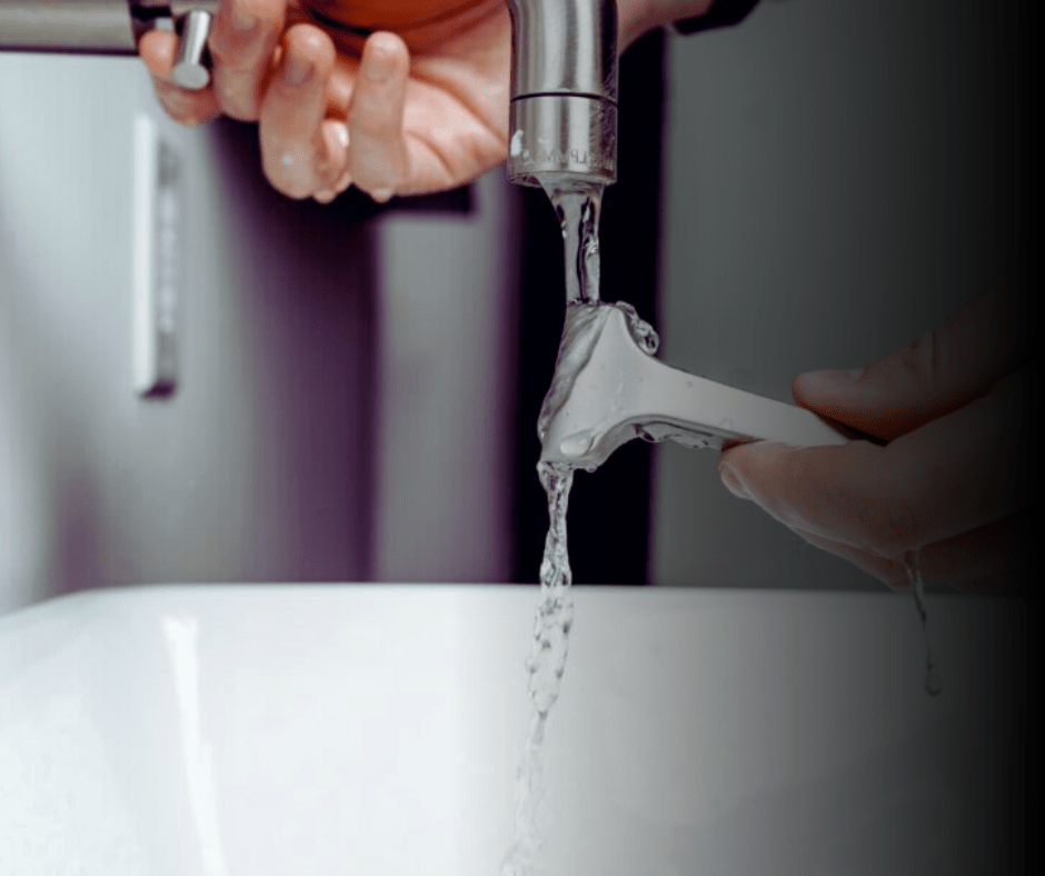 Person rinsing razor under running tap water.