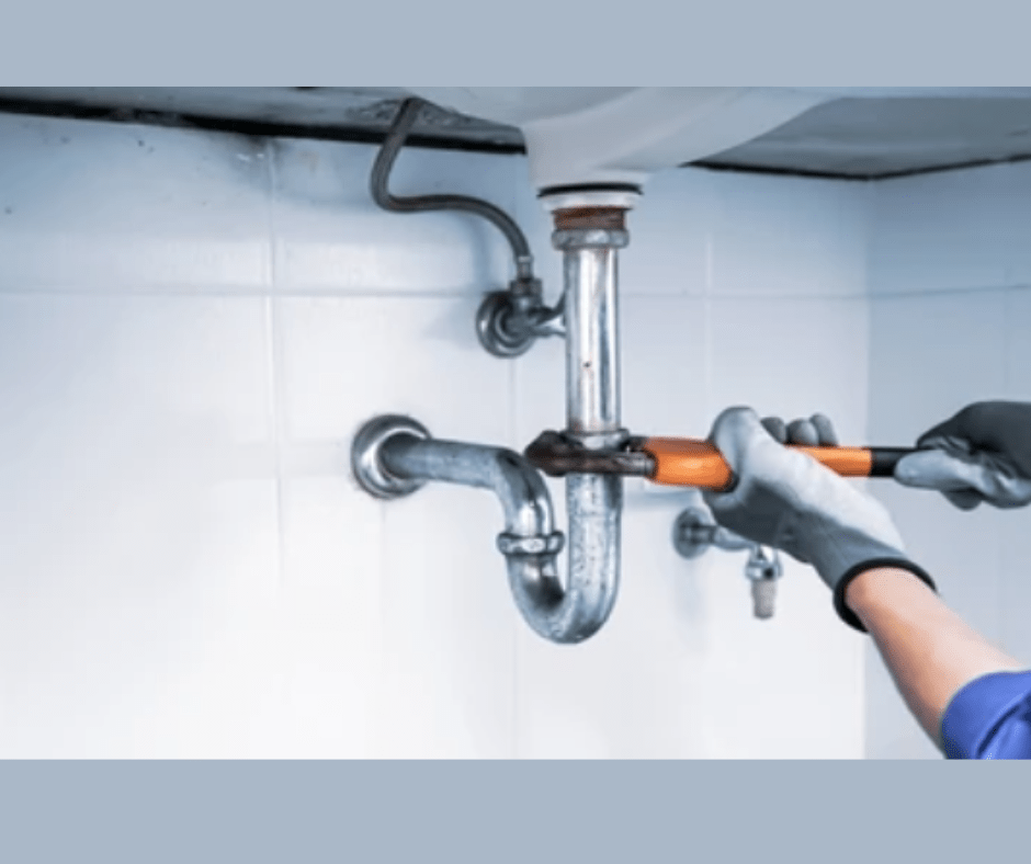 Plumber fixing sink pipe with wrench under basin.