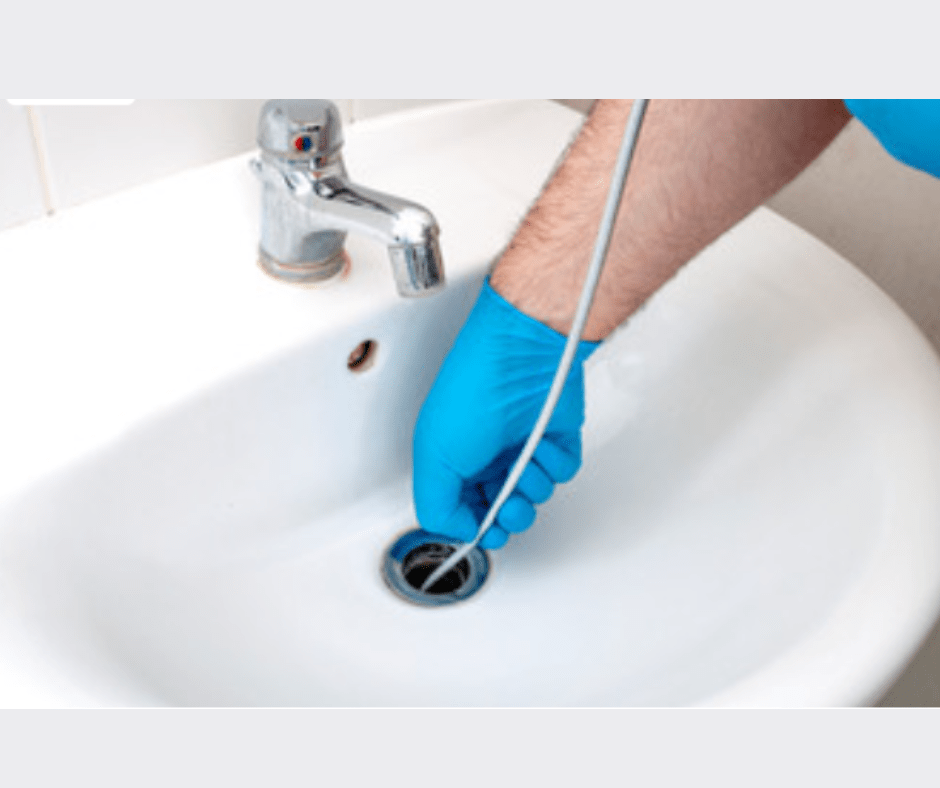 Unclogging bathroom sink with hand tool.