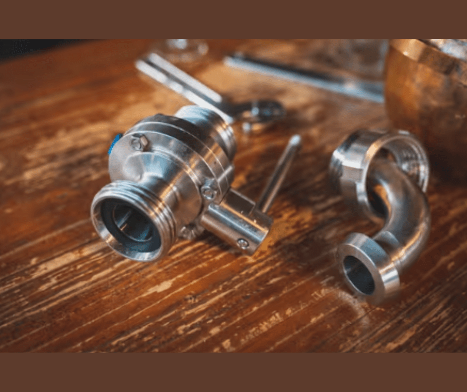 Stainless steel pipe fittings on wooden surface.