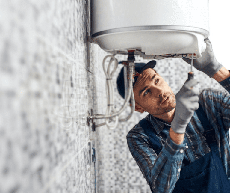 Plumber repairing an under-sink water heater.